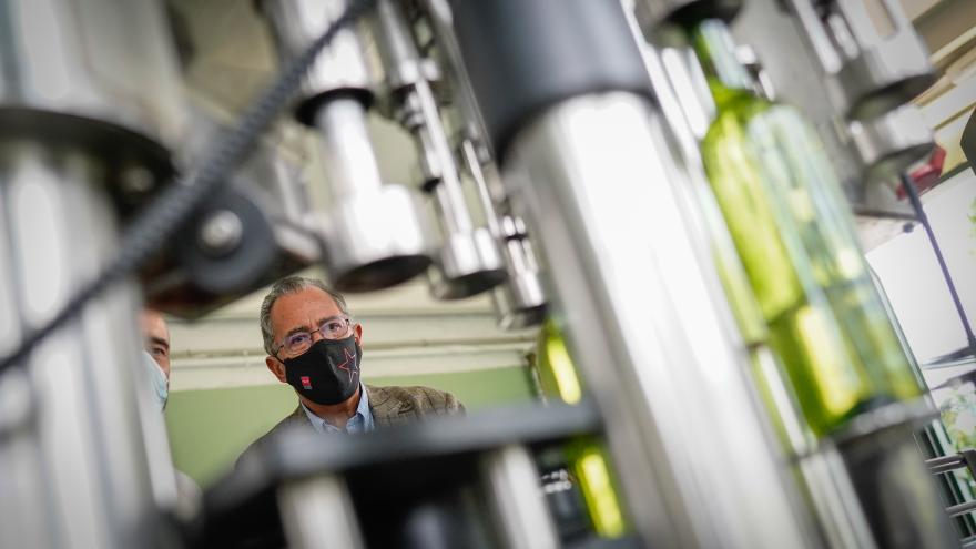 Primer plano del consejero mirando una de las máquinas productoras de vino