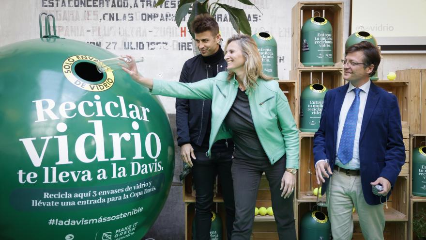 La consejera depositando una botella de vidrio en un contenedor