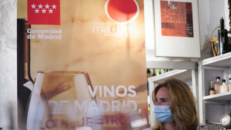 Primer plano de la consejera con el cartel oficial Vinos de Madrid de fondo