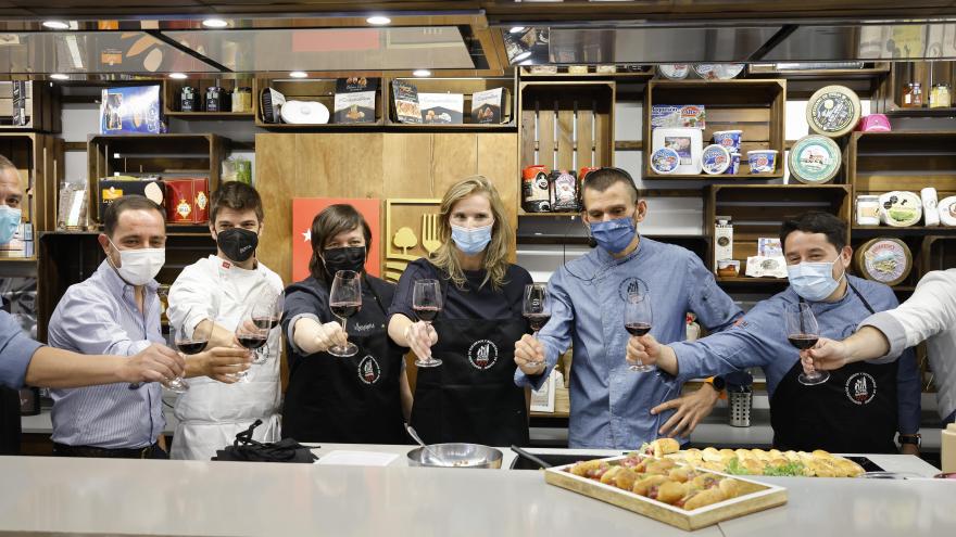 Foto de participantes brindando con una copa de vino