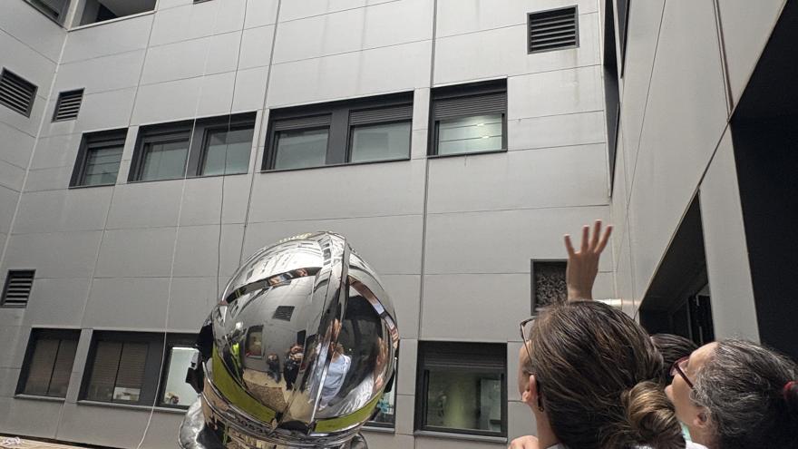 bomberos realizando una exhibición de rapel por fachada interna del hospital
