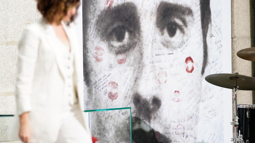 La presidenta de perfil vestida de blanco con un fondo con el rostro de Miguel Ángel Blanco