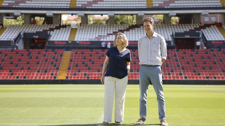 La consejera Marta Rivera escucha la explicación de una persona en el césped