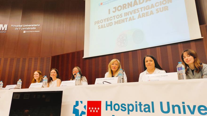 Mujeres sentadas en un mesa con una proyección al fondo