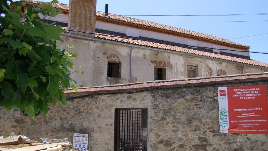 Muro norte con la nueva puerta-reja Imagen de un edificio con fachada de piedra y una puerta con reja