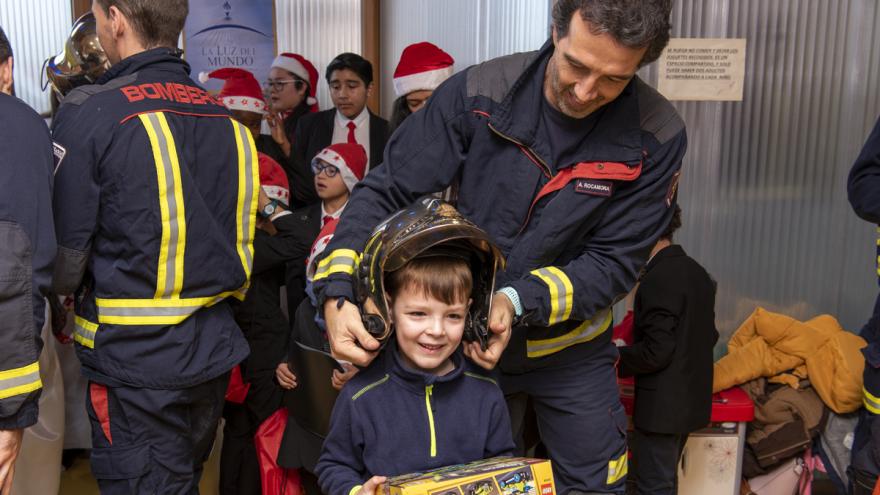 Los niños han podido probarse el casco de bombero