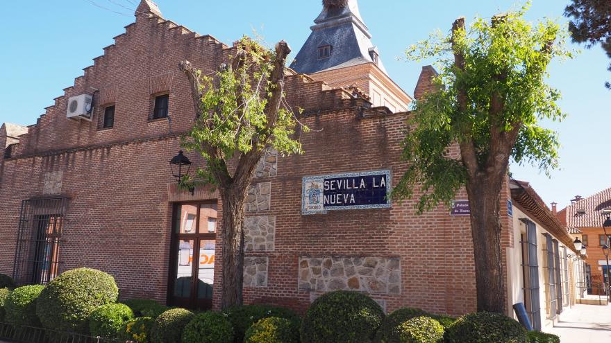 Fachada de edificio de ladrillo con cartel de azulejería de Sevilla la Nueva