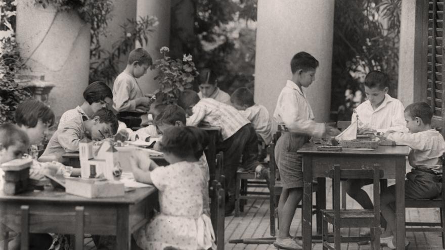 terraza con sillas y mesas donde descansa un grupo de niños y niñas
