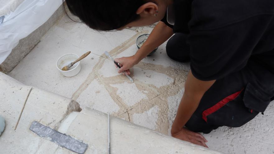 Restauradora con brocha y herramientas de reparación de grietas sobre prieda