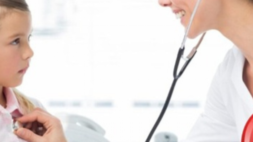 Doctora a la derecha auscultando a una niña a la izquierda