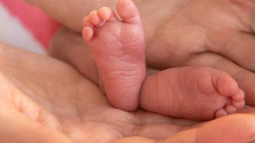 Piececitos de un bebé prematuro entre las manos de un adulto