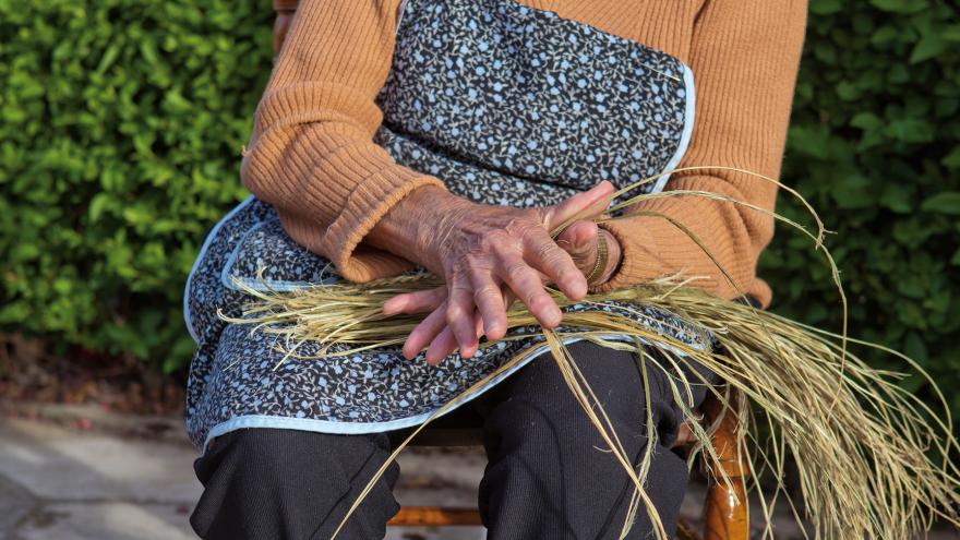 una mujer hilando esparto