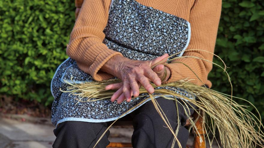 una mujer hilando esparto