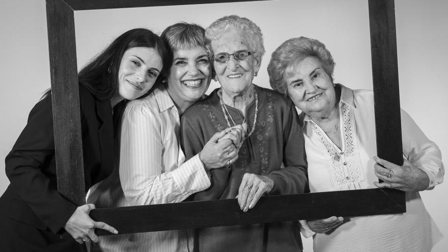 Cuatro mujeres de distintas edades sujetan un marco 
