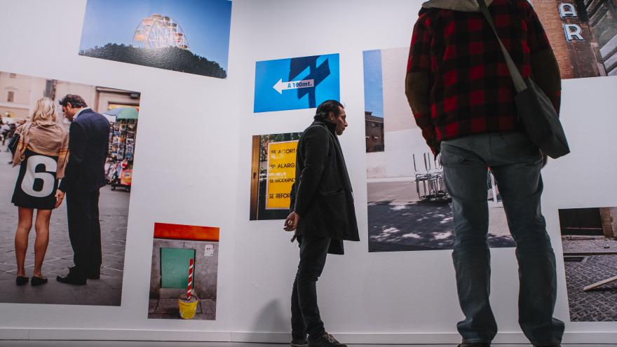 Dos hombres viendo una muestra fotográfica en una planta de la Sala Canal