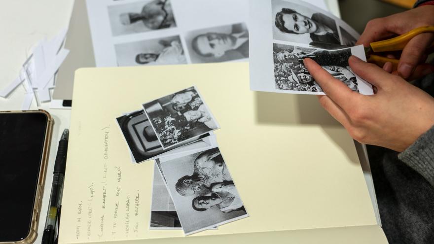 Manos recortando imágenes y componiendo un collage en un libro en blanco
