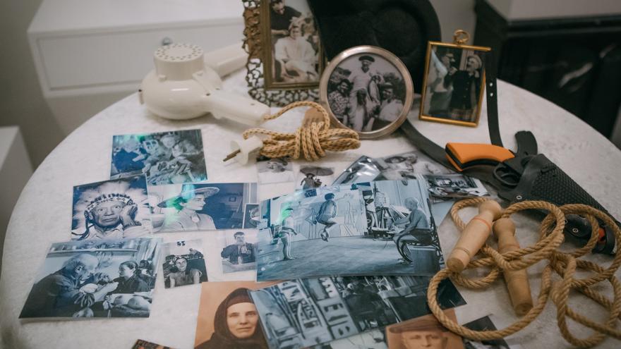 Mesa camilla con fotografías antiguas desordenadas sobre ella