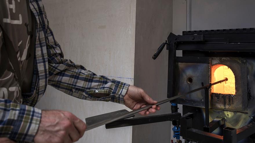 Taller soplado de vidrio Hombre manejando herramientas para soplado de vidrio