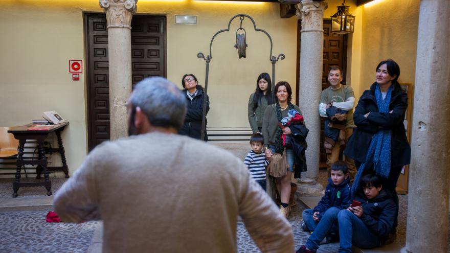Actor de espaldas interpretando en el patio del Museo Cervantes frente a un grupo de visitantes