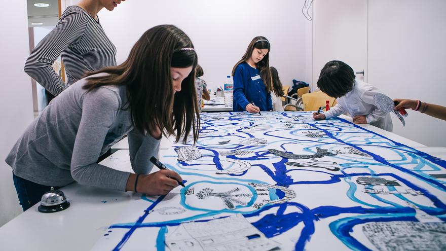 Taller creativo. Foto: Guillermo Gumiel Niños pintando con pinceles líneas curvas en distintos tonos de azul