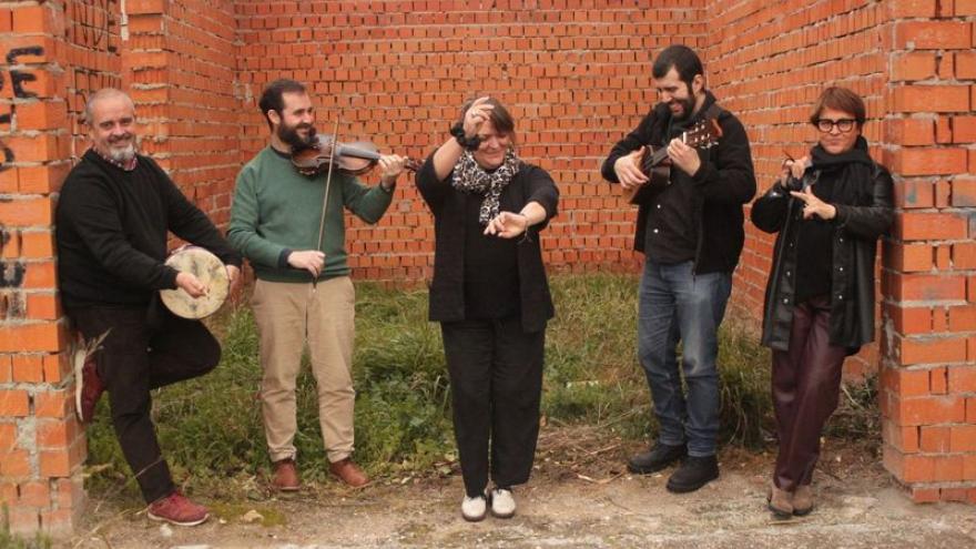 El grupo Vigüela tocando delante de una pared de ladrillo rojo
