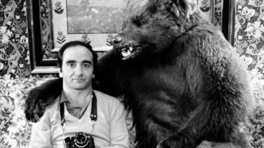 Hombre con cámara fotográfica acompañado de un oso