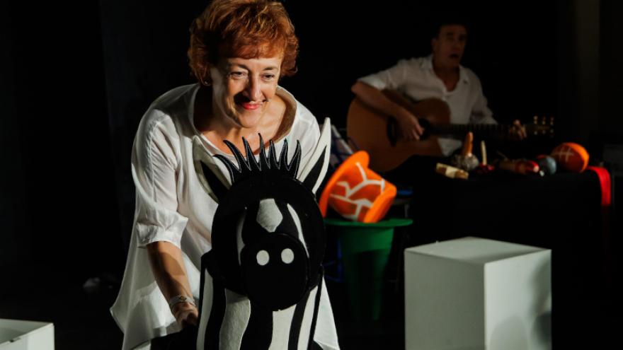 IMAGEN DE ESCENA DONDE LA ACTRIZ MANIPULA UN TÍTERE DE UNA CEBRA