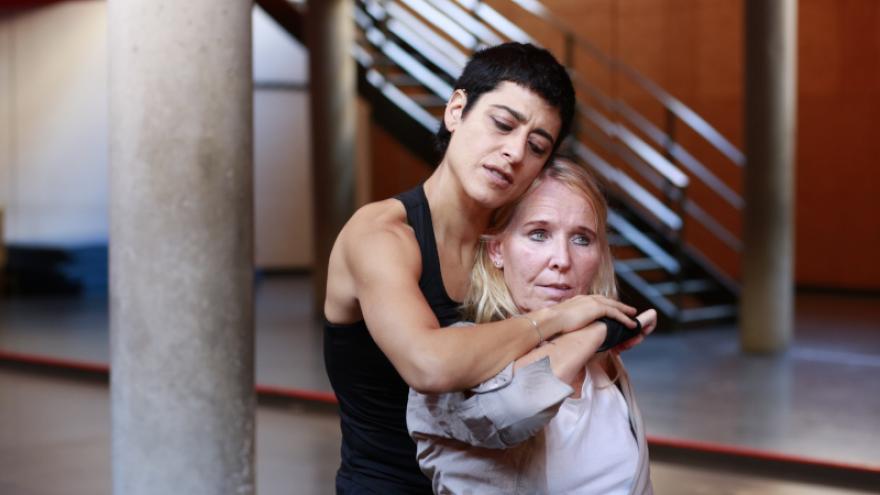imagen de dos mujeres bailando una en silla de rueda , la otra la toma por las manos 