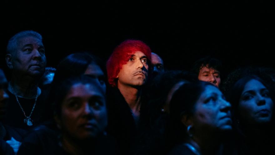 FOTOGRAFÍA DE QUENTÍN ENTRE UN CORO , LE ILUMINA UN FOCO