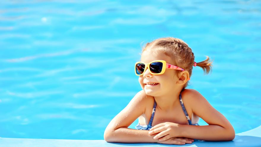 Niña sonriente en el borde de la piscina