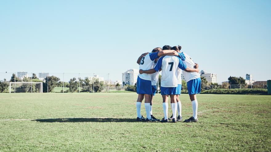 Equipo de jugadores de fútbol en un grupo en un campo para motivarse antes de un juego