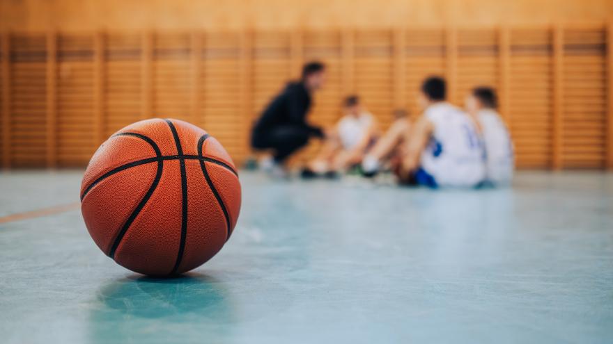 Pelota de baloncesto en la cancha con equipo al fondo