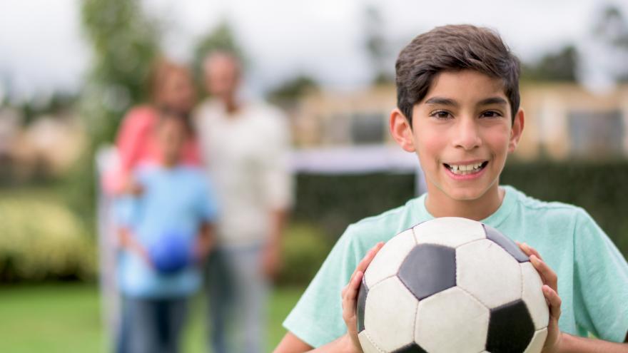 Niño jugando al fútbol con su familia