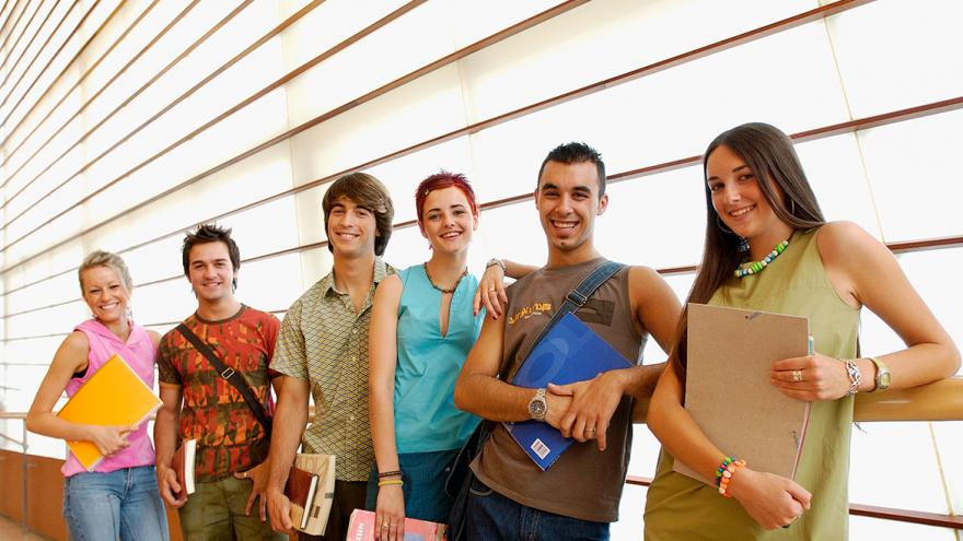 Seis estudiantes de pie posan sonrientes