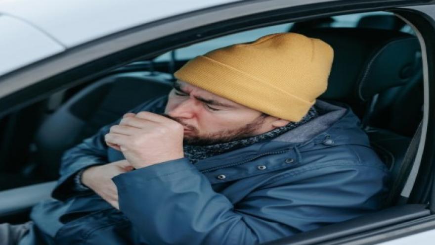 persona tosiendo en el interior de un coche