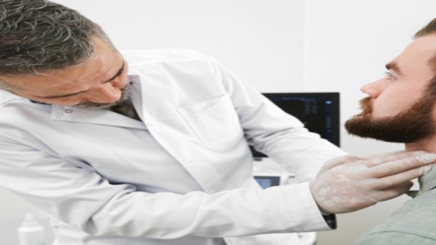 Imagen de medico explorando el cuello a paciente.