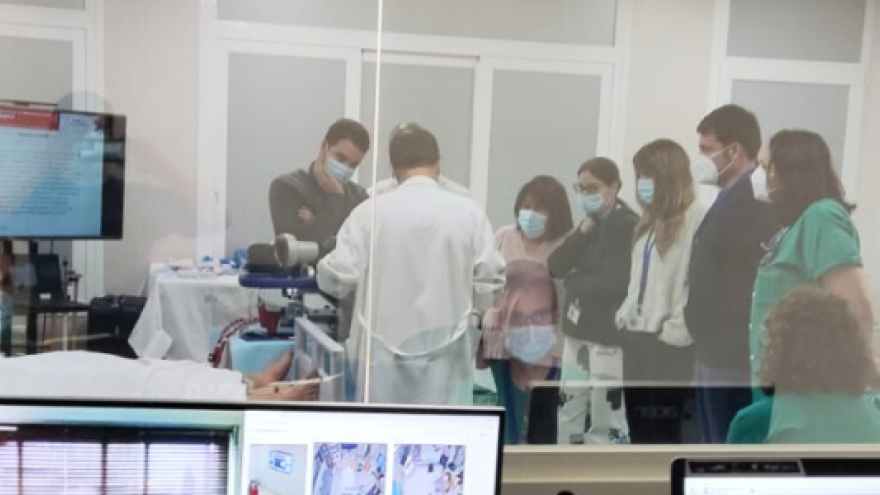 profesionlaes sanitarios simulando una intervención y vistos a través de un cristal