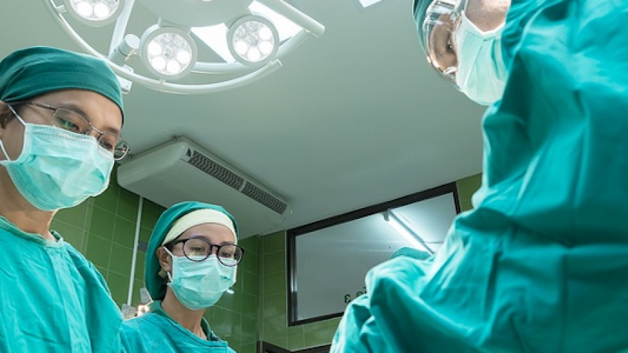 Imagen de tres personas en un quirófano