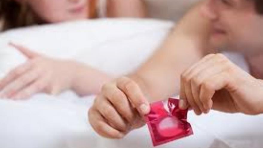 Pareja abriendo preservativo