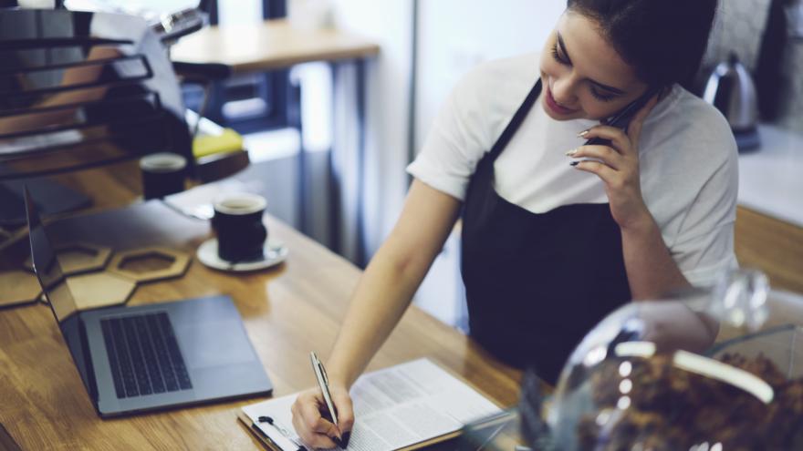 Una mujer atiende una llamada en un bar que es una franquicia