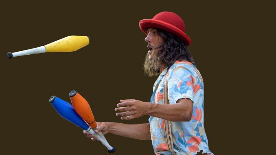 chico haciendo malabares encima de monociclo
