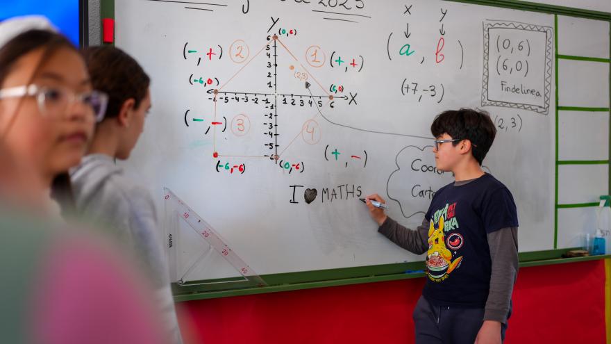 alumno escribiendo con profesor de matemáticas 