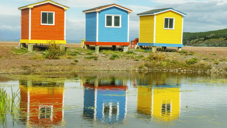 Casetas de madera de colores con reflejos en el agua