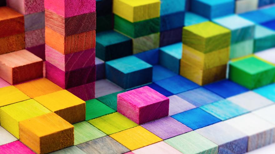 cuadraditos de madera de distintos colores apilados más y menos cantidad