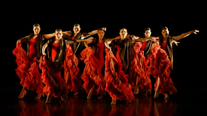 Bailarinas sobre un escenario con trajes rojos de flamenco