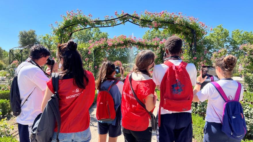 Jóvenes haciendo fotos a plantas de un jardin