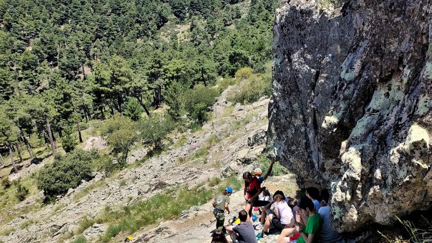 Jóvenes sentados preparados para escalar pared de piedra