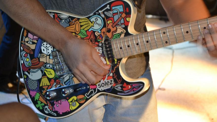 chico tocando guitarra colores
