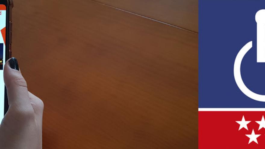 Pantalla de inicio de la App "Tarjeta de discapacidad" en un móvil que sujeta una mano.