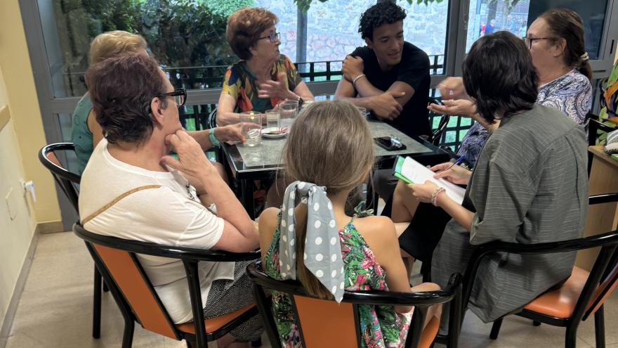 reunión en torno a mesa de gente joven y mayor
